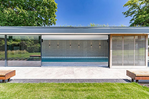 Contemprary Pool House viewed from the outside with open doors.