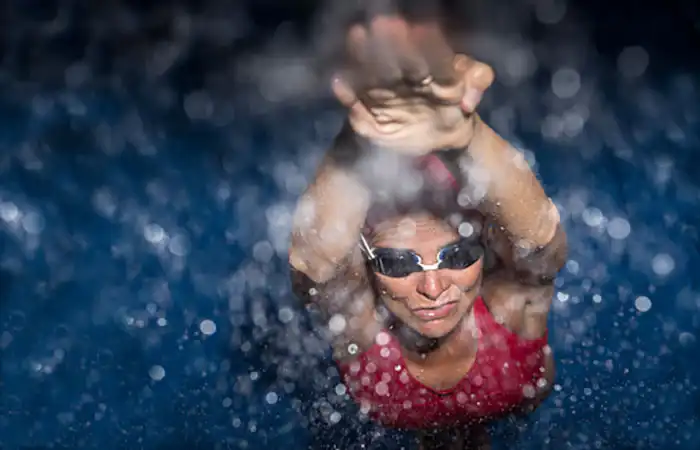 woman diving into a pool, viewed from underwater