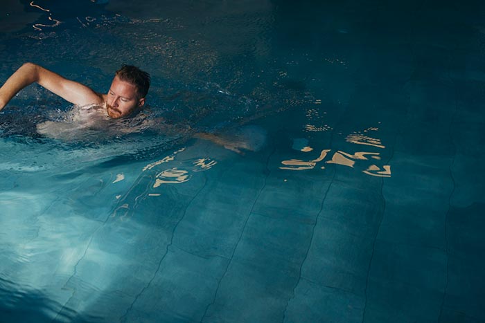 man swimming in pool
